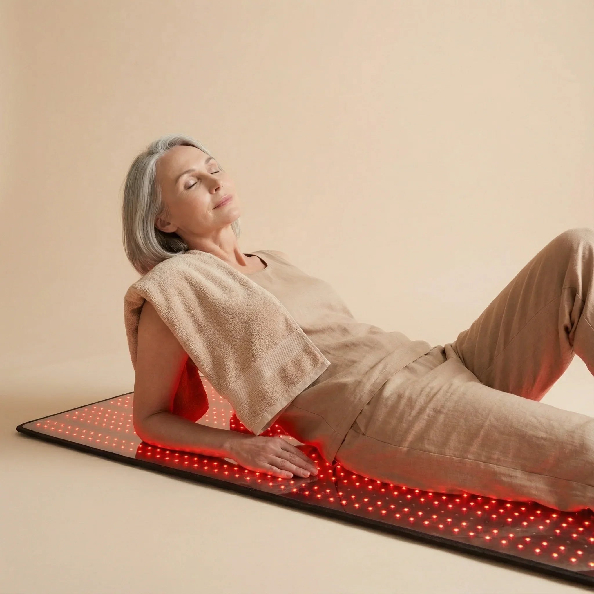 Woman enjoying Nicebeam Full Body Red Light Therapy Mat with red light for skin rejuvenation and wellness.